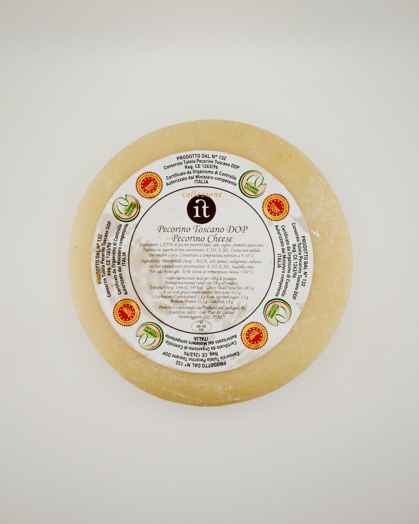 Round sheep cheese with a label on a white background