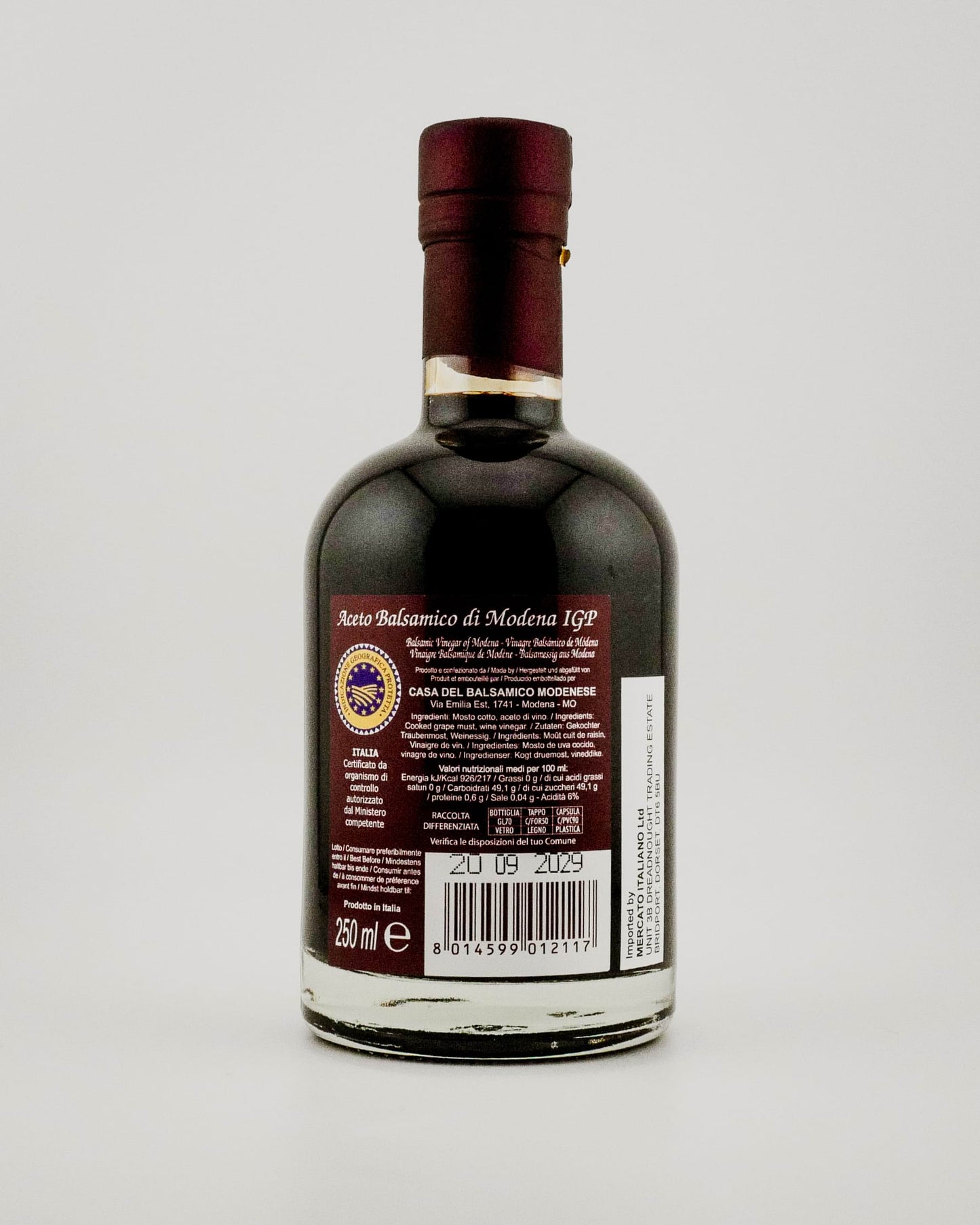 Bottle of balsamic vinegar with a label on a white background