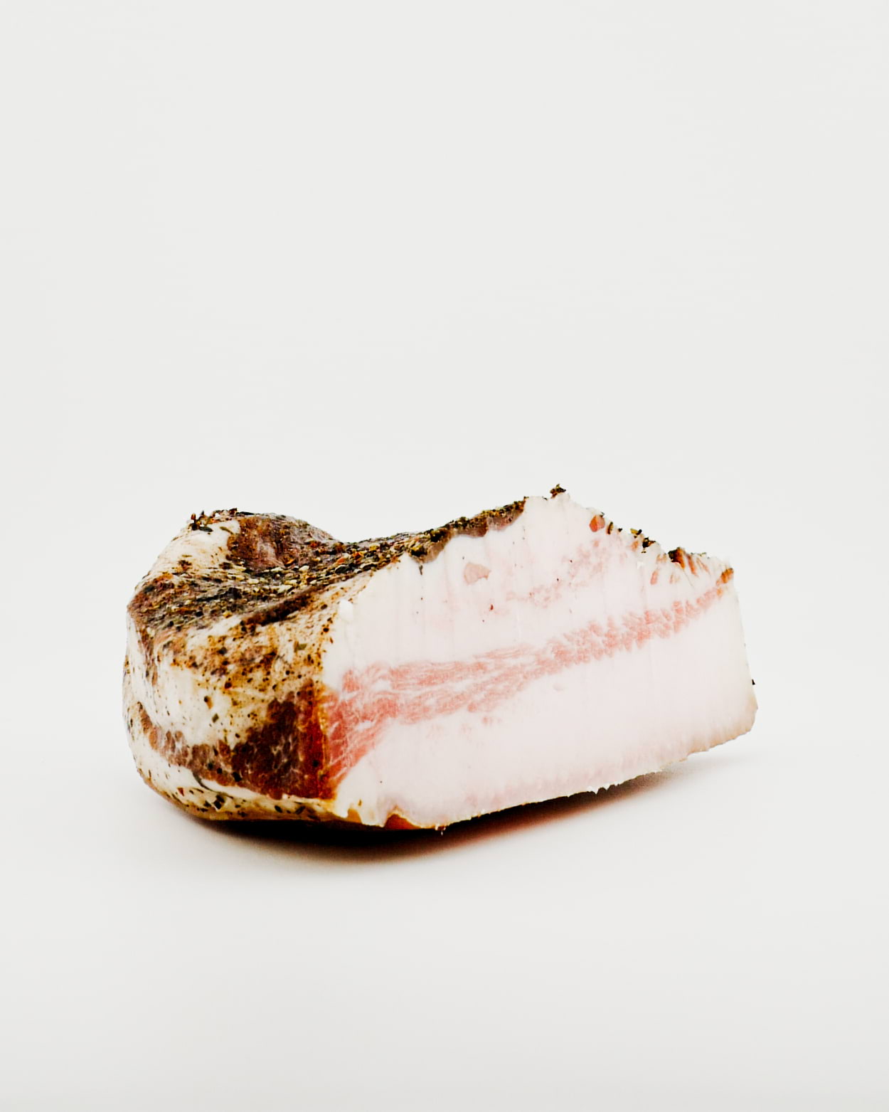 Block of raw pork belly on a white background