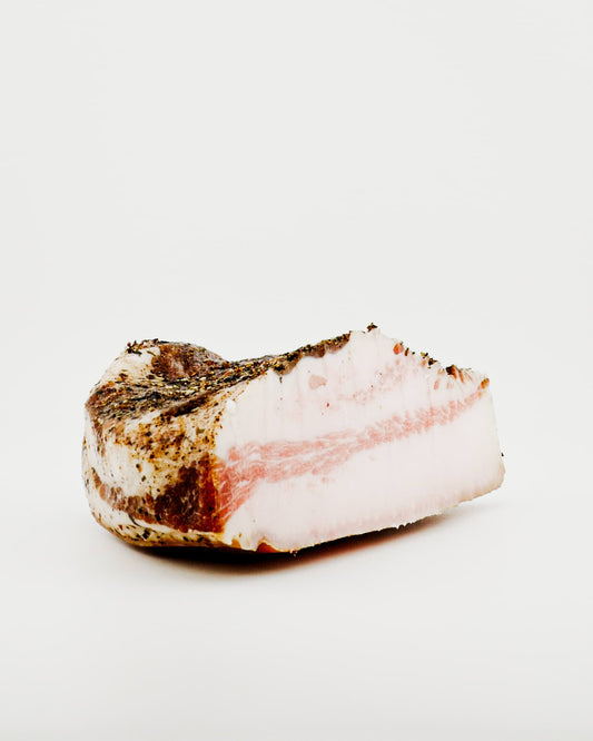 Block of raw pork belly on a white background