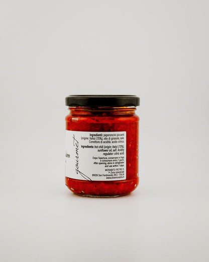 Jar of red Spicy Calabrian Chillis with a black lid on a white background