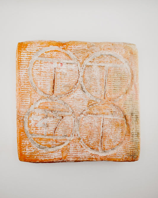 Square piece of soap with circular grooves on a light gray background